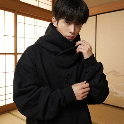 Hombre con sudadera negra de estilo japonés en una sala tradicional con paneles shoji