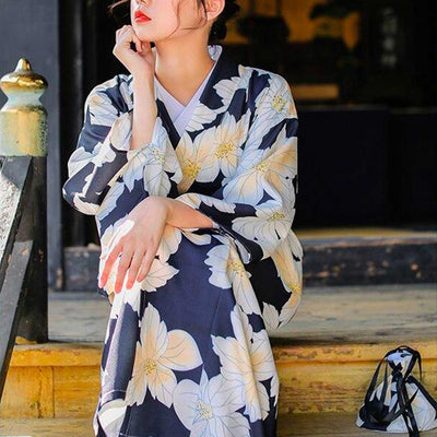 Kimono japonés floral con motivos amarillos, mujer elegante con un kanzashi de flor en el pelo