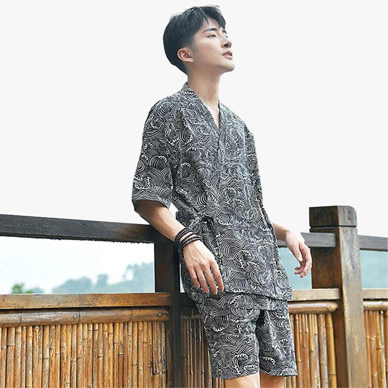 Un hombre vestido con un kimono Pijama​ japones estampado con motivos de olas japonesas.