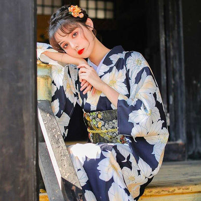 Kimono amarillo mujer con estampado floral japonés, mujer luciendo un kanzashi de flor en el cabello
