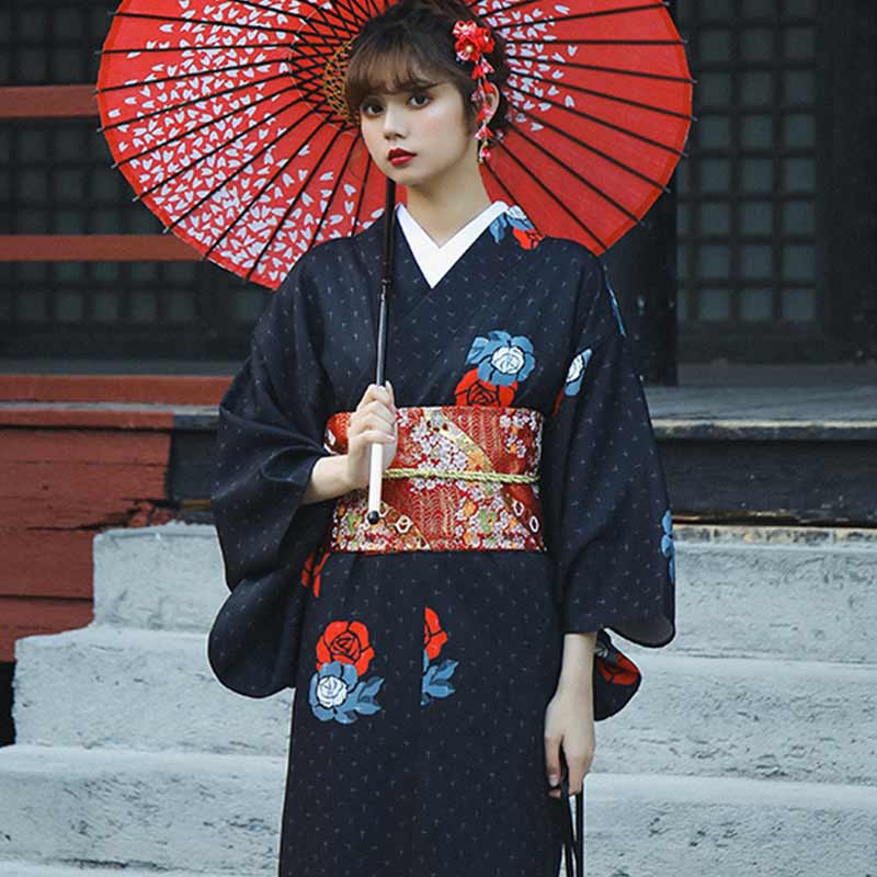 Mujer con kimono y cinturón obi rojo sosteniendo un paraguas