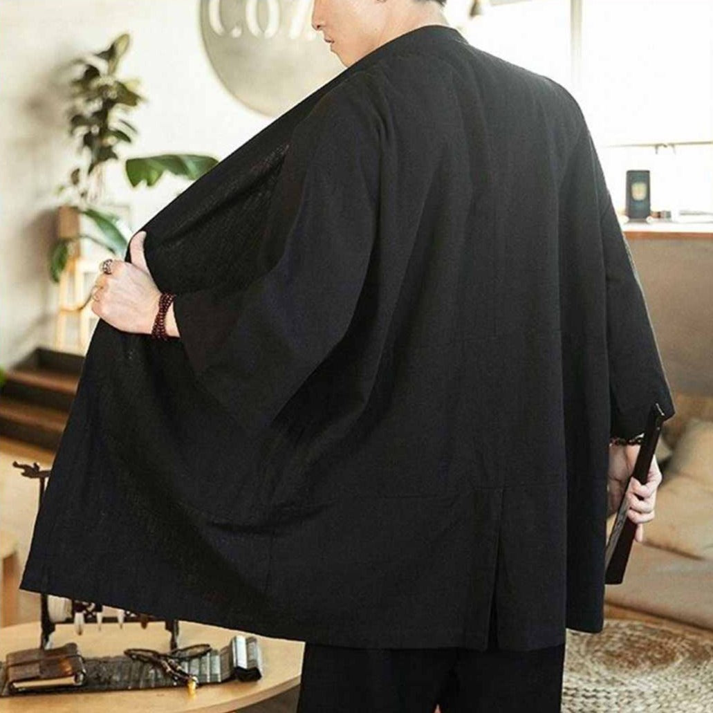Kimono haori negro con líneas limpias y caída suave, que refleja la elegancia del estilo japonés clásico en la ropa moderna.