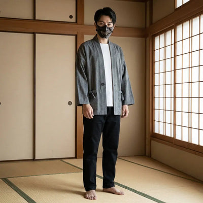 Hombre con un kimono japonés para hombre en una habitación washitsu tradicional, vista frontal