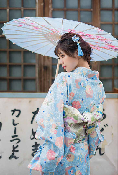 Kimono mujer con flores japonesas estampadas, la mujer posa con gracia sosteniendo un wagasa tradicional