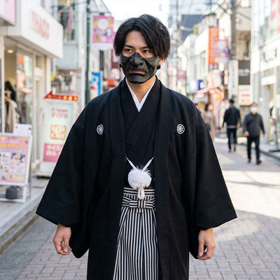 Detalle frontal del kimono negro con haori y hakama de rayas