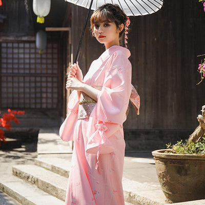 Mujer con kimono tradicional japonés y obi sakura geisha en la cintura, sombrilla japonesa y kanzashi en el cabello