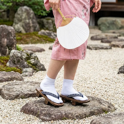Geta Seigaiha combinadas con un kimono rosa en un jardín japonés