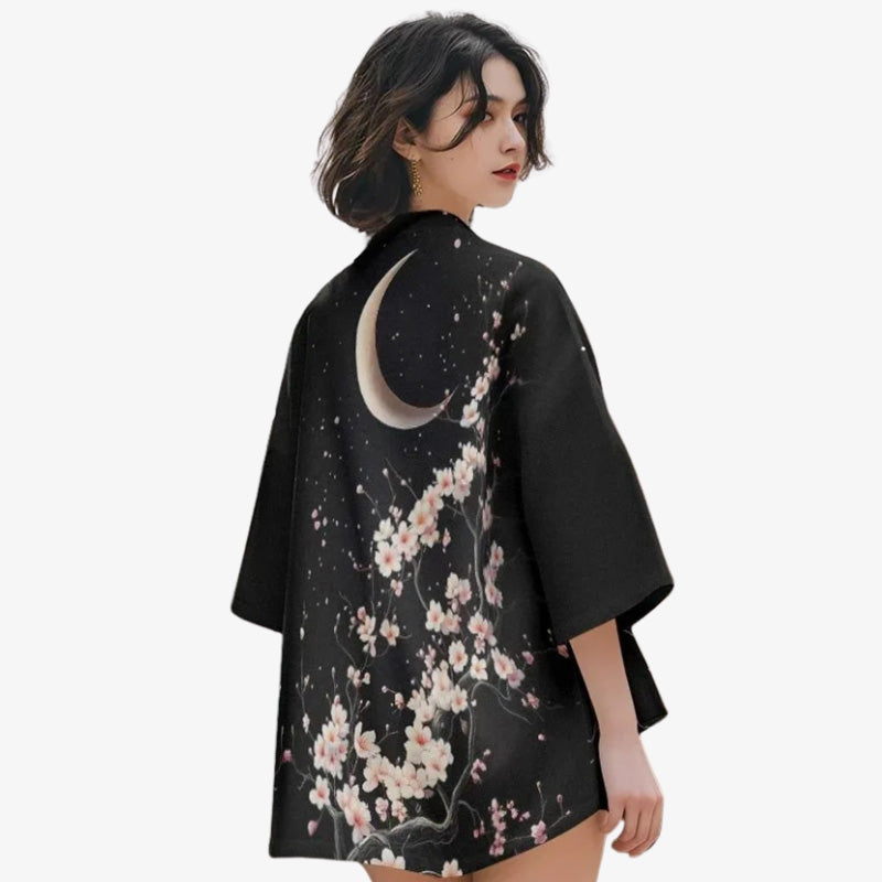 Mujer luciendo un kimono sakura con delicados motivos de flores de cerezo y luna, evocando la belleza de la primavera japonesa