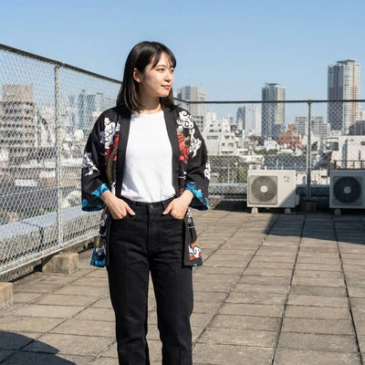 Chaqueta kimono de mangas turquesa fotografiada en una terraza urbana, con las manos en los bolsillos