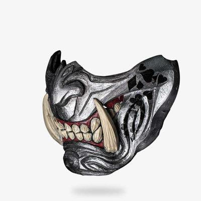 Es la mascara de la tragedia samurai​ de color gris con colmillos