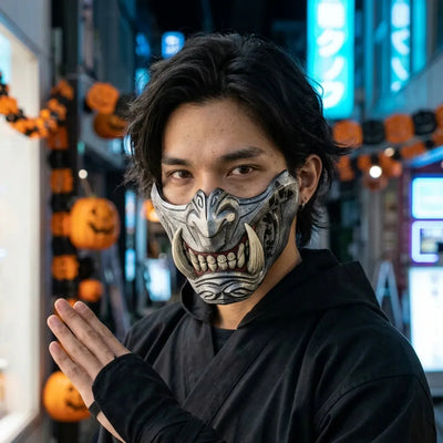Mascara oni de plata con colmillos de marfil, usada de noche para Halloween con el neon azul de Tokio de fondo