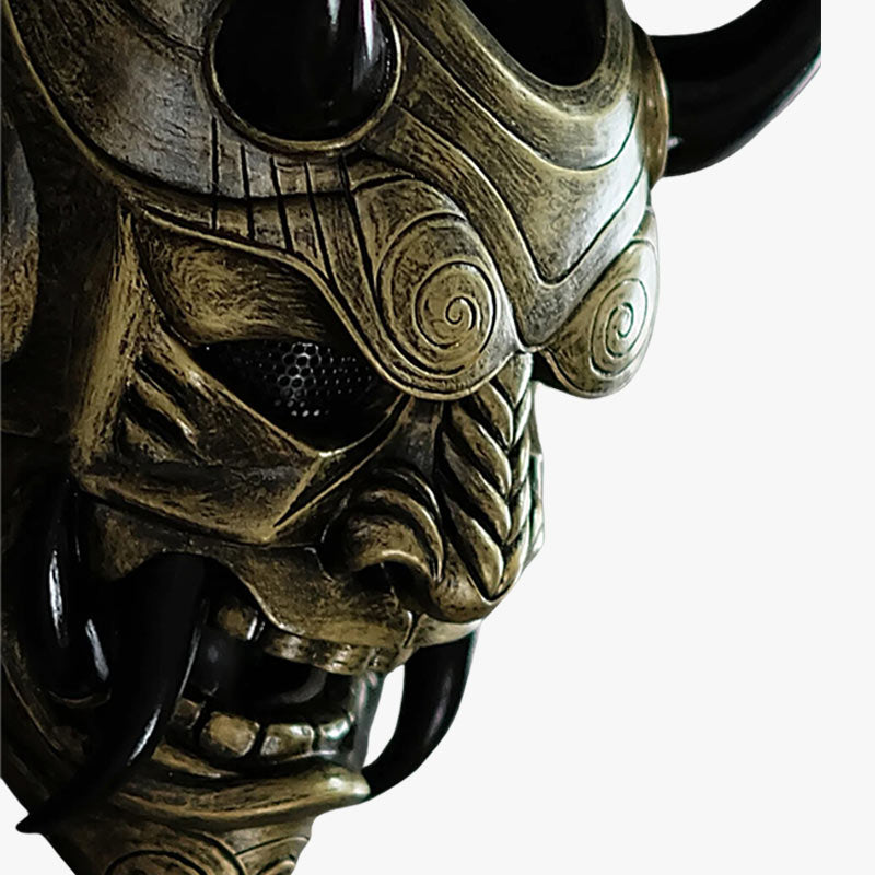 La máscara tradicional japonesa de Oni samurái de color dorado es una pieza artesanal, hecha de fibra de vidrio y madera, que representa al legendario demonio Oni con detalles pintados a mano, cuernos y afilados dientes negros.