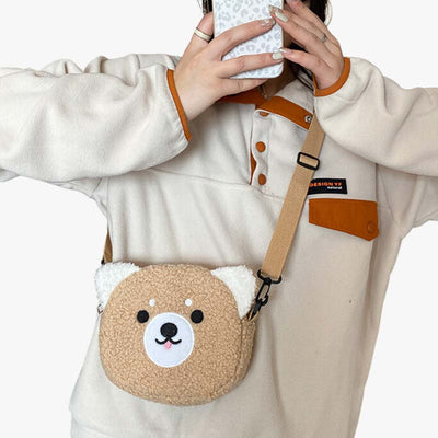 Mujer con jersey llevando un bolso kawaii bandolera con forma de osito mientras se hace una foto con el móvil