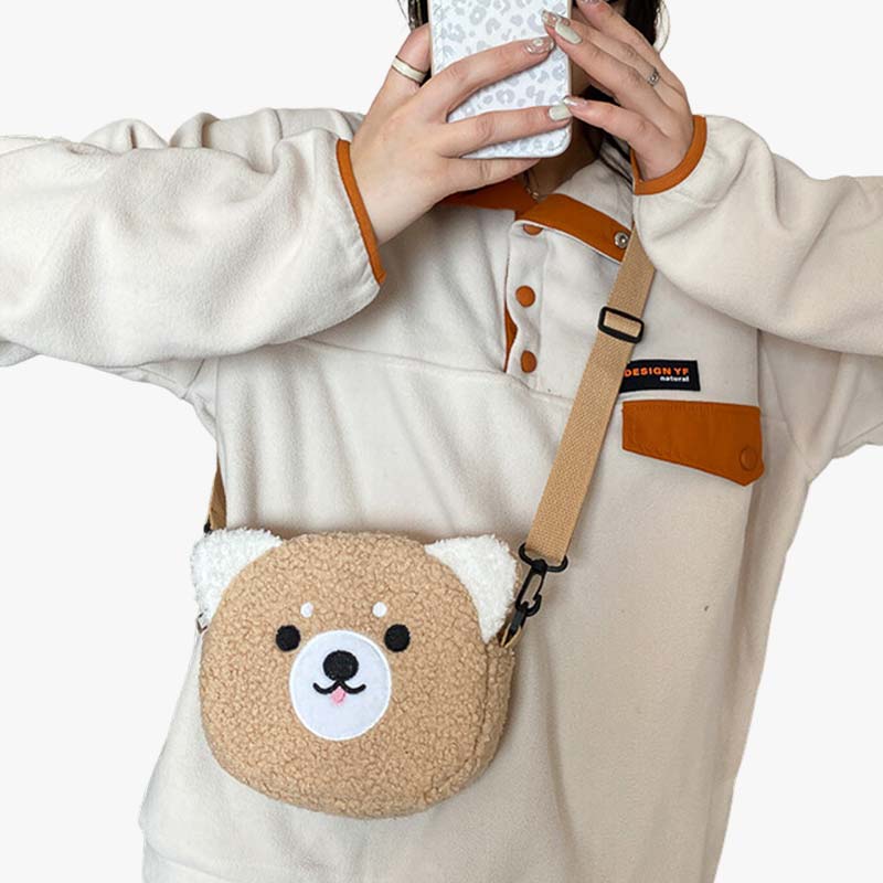 Mujer con jersey llevando un bolso kawaii bandolera con forma de osito mientras se hace una foto con el móvil