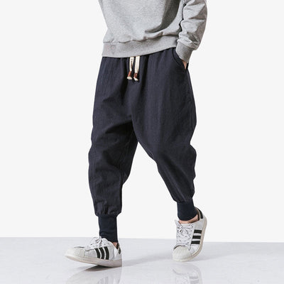 Hombre japonés con pantalón japonés ajustado en el tobillo y sudadera con capucha gris