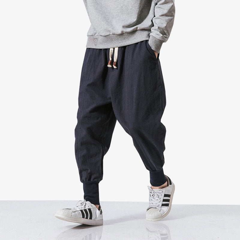 Hombre japonés con pantalón japonés ajustado en el tobillo y sudadera con capucha gris