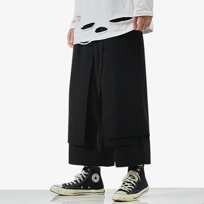 Un hombre viste pantalon Japones hakama de color negro y tenis negros