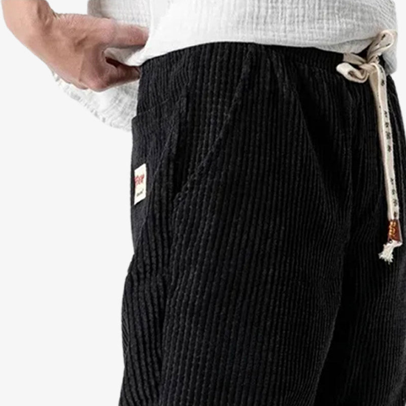 Pantalón de pana negro combinado con streetwear japonés moderno para un look casual y refinado
