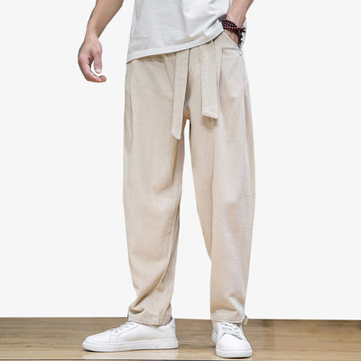 Un hombre lleva pantalones holgados de estilo japonés con un cinturón obi alrededor de la cintura.