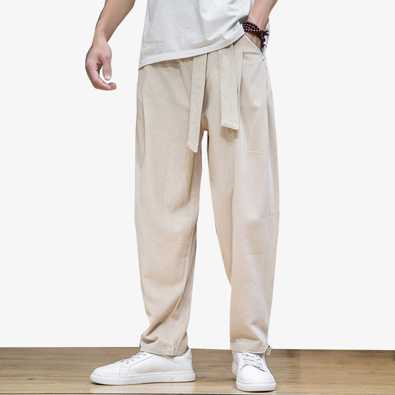 Un hombre lleva pantalones holgados de estilo japonés con un cinturón obi alrededor de la cintura.