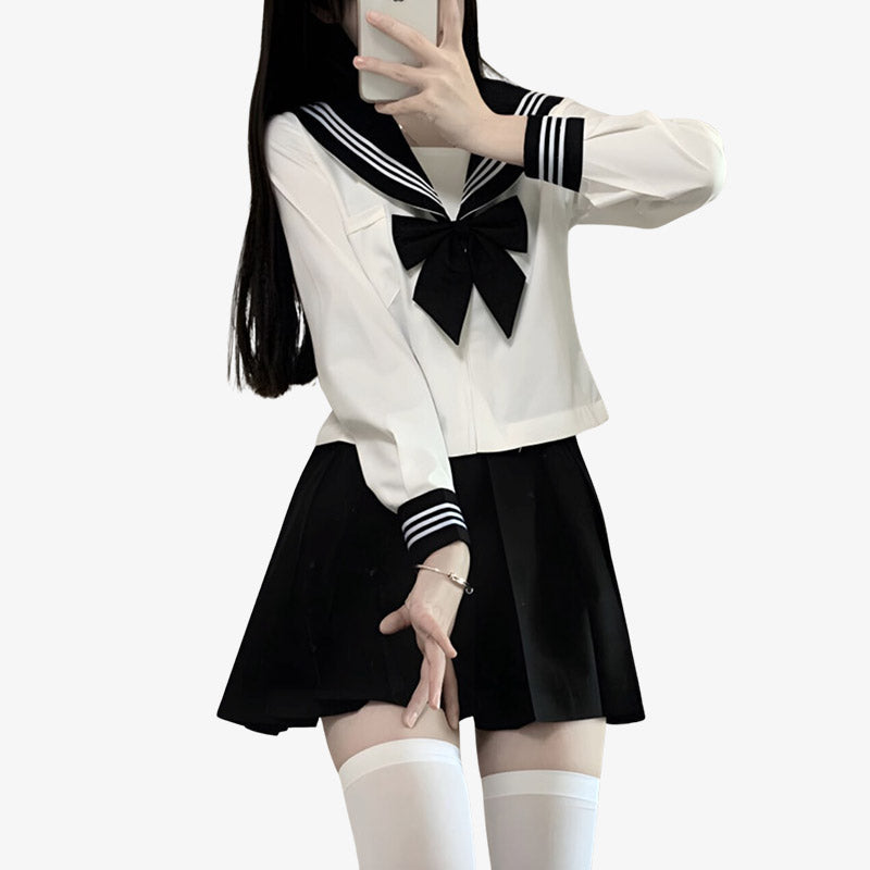 Una niña viste un uniforme sailor fuku cosplay con falda negra japonesa, moño negro japonés y camisa blanca japonesa de estudiante.