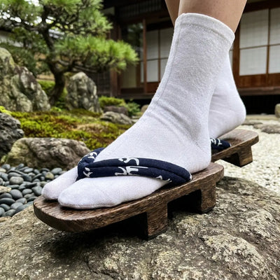 Primer plano de la tira hanao azul marino con caracteres blancos en las sandalias geta