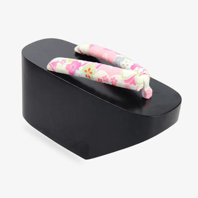 Sandalias geta de plataforma para geisha, usadas históricamente en artes escénicas y ceremonias. La correa lleva estampado de flores japonesas. La madera es de color negro