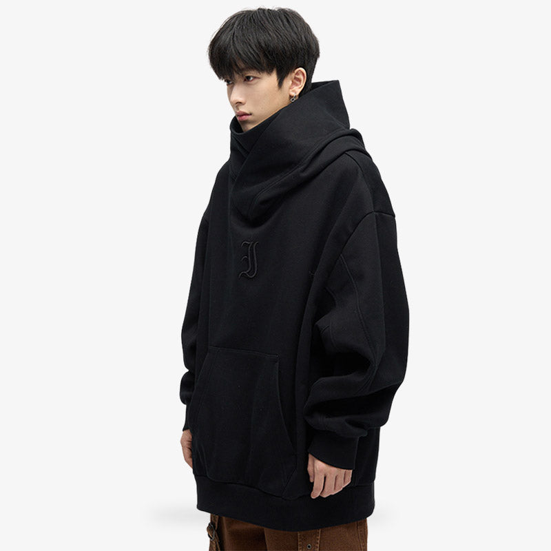 Un hombre japonés está de pie y viste una sudadera con capucha tipo ninja de Harajuku. La sudadera japonesa esta diseñada con un color negro minimalista y un material resistente, ideal para un look urbano japonés moderno y atrevido.
