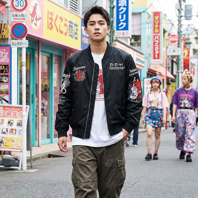 Hombre con sukajan japonés y texto blanco bordado en Harajuku