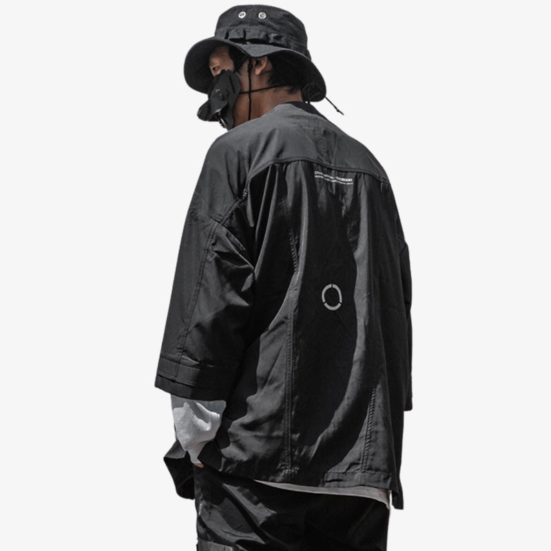 Un hombre japonés lleva un kimono negro de ropa techwear fashion. El tejido es impermeable.