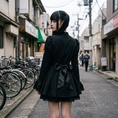 Vista trasera del vestido lolita oscuro en Harajuku, con el lazo de raso atado a la cintura y la falda plisada