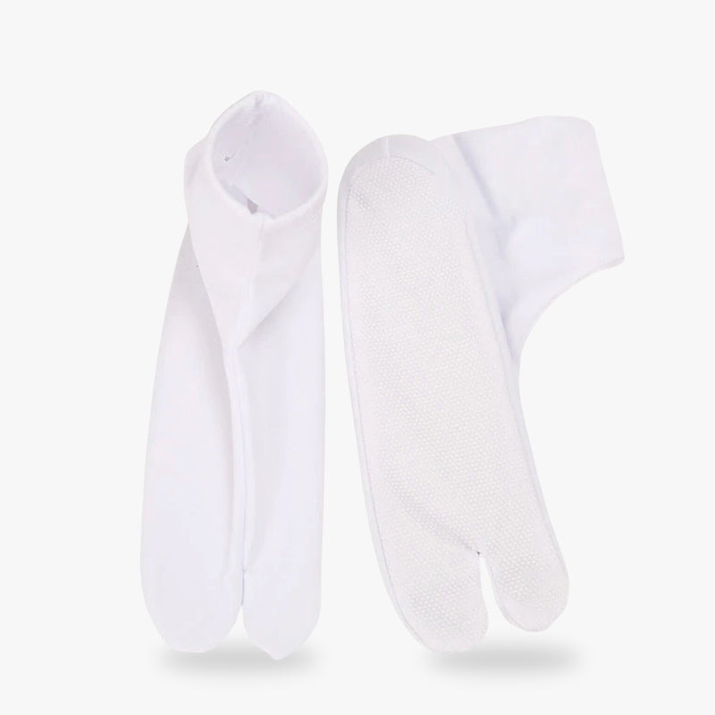 Un par de calcetines japoneses tabi blancos con diseño de dedos separados, mostrados sobre un fondo blanco.